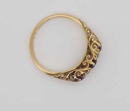 An Edwardian 18ct gold, three stone ruby and four stone diamond set half hoop ring, size K, gross weight 3.4 grams. Condition - fair